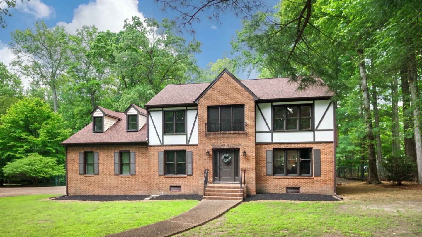Brick Tudor-style home surrounded by mature trees at Winterfield Road